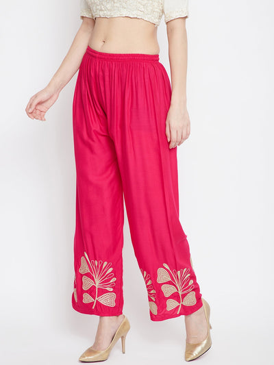 Magenta embroidered straight palazzo pants with floral design at the hem.