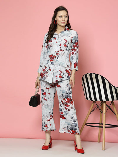 Woman wearing grey floral printed shirt and trousers co-ords with red and black accents.