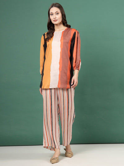 Geometric printed tunic with striped trousers co-ords in orange and black tones.