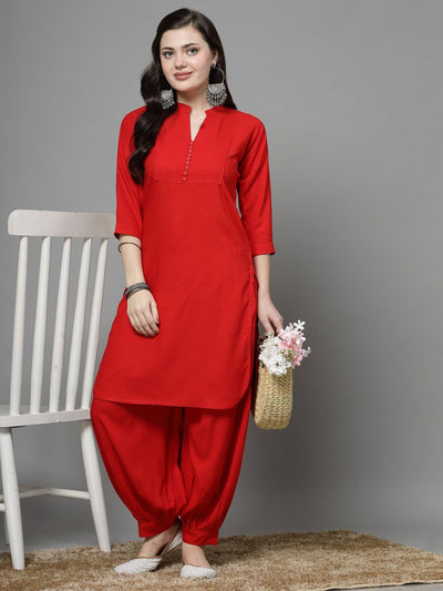 Yoke design red kurta with Afghani pants, featuring three-quarter sleeves and cuffed hem.
