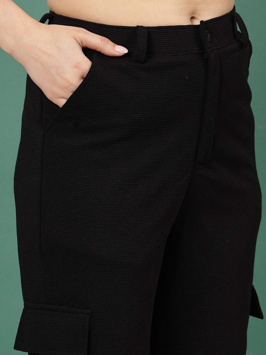 Black solid flat front mid rise corduroy cargo trousers.