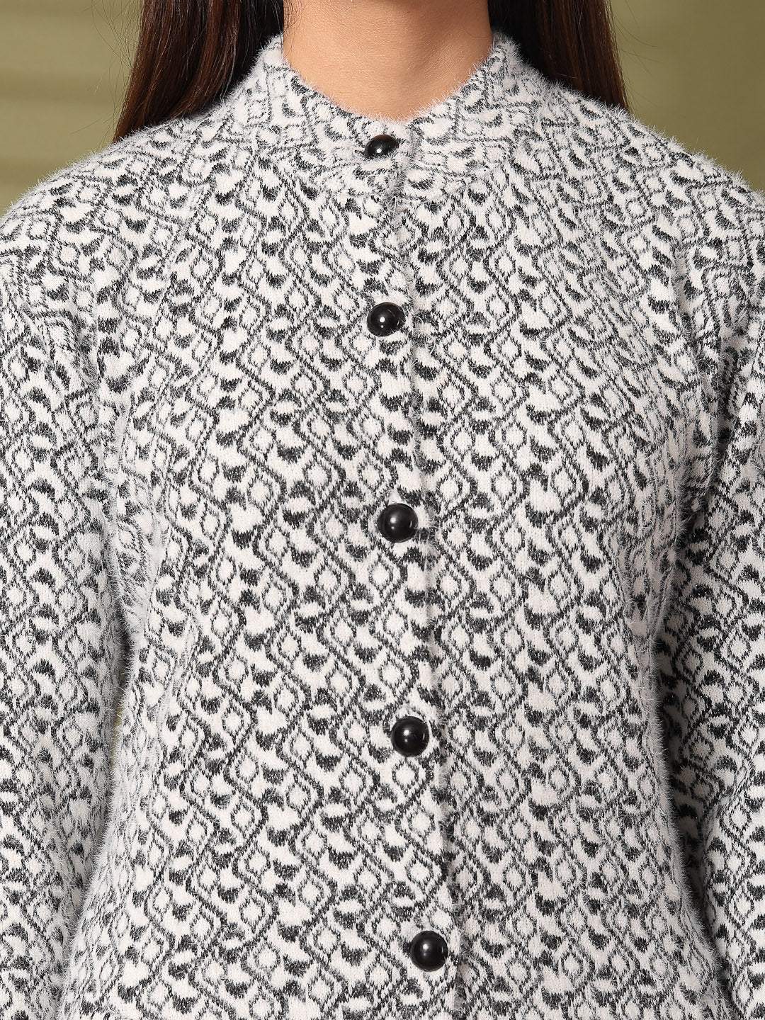Black woolen knitted cardigan with full sleeves and button detailing.
