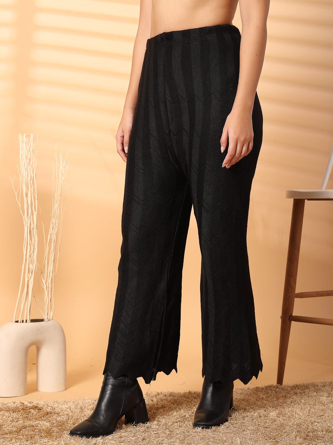 Black solid cut work woolen palazzo with intricate hemline detailing.