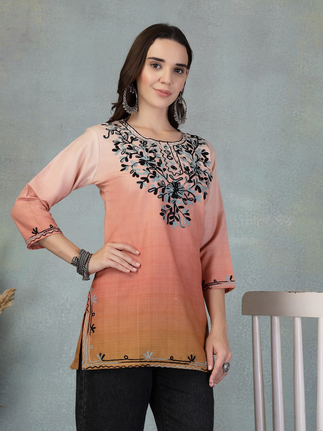 woman wearing peach embroidered rayon kurti with floral design and black pants