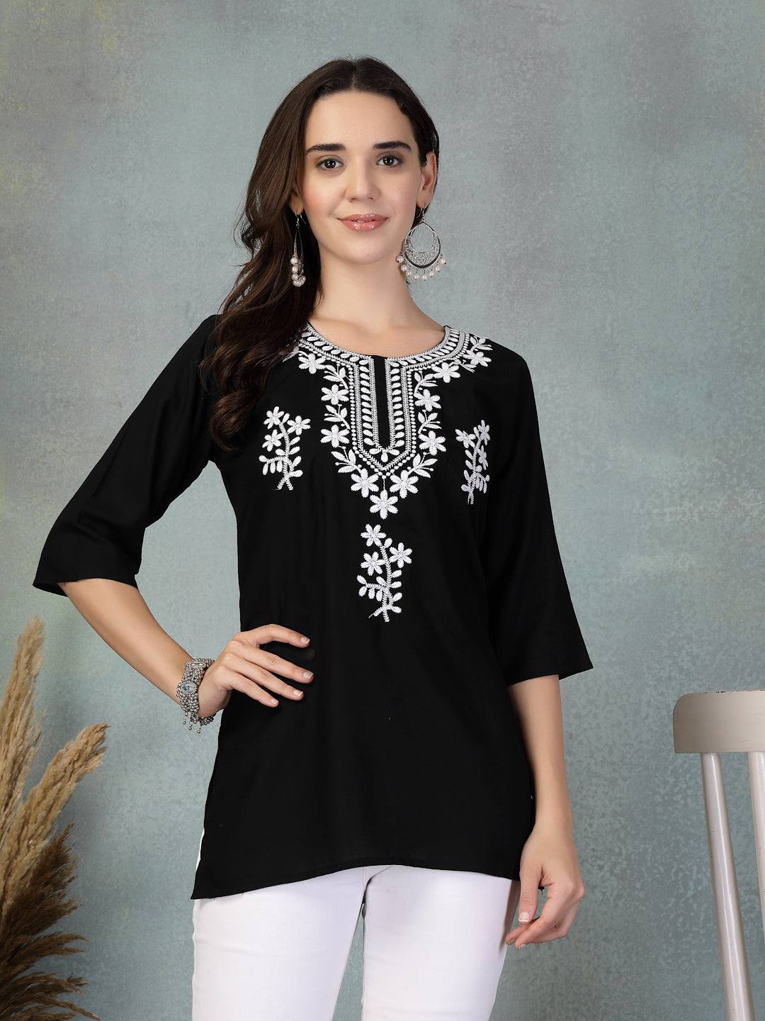 Black embroidered rayon kurti with white floral embroidery, worn with white pants for a casual chic look
