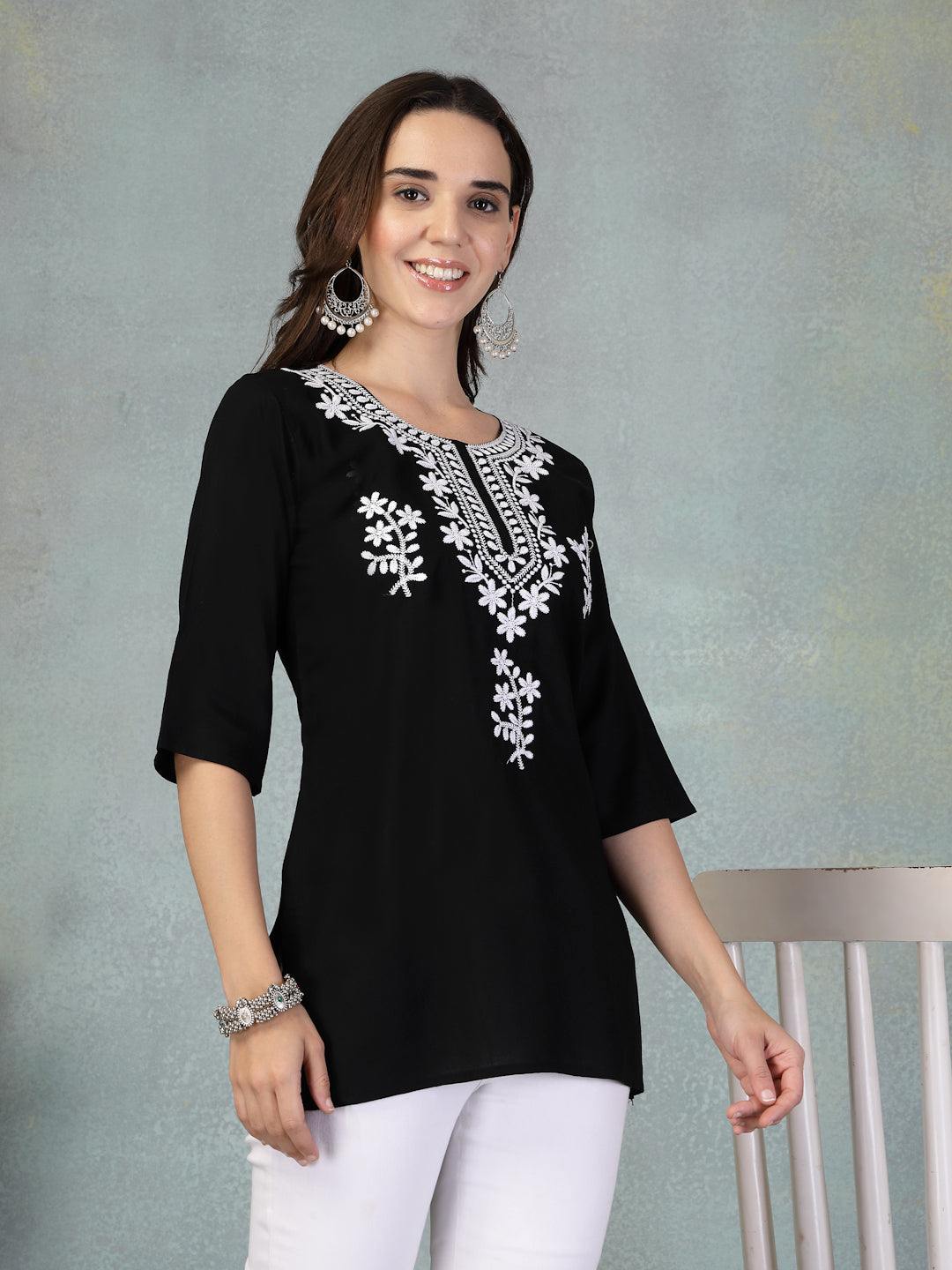 Black embroidered rayon kurti with white floral patterns worn with white leggings