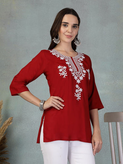 Maroon embroidered rayon kurti with white floral embroidery and three-quarter sleeves worn with white pants
