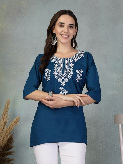 Peacock blue embroidered rayon kurti with white floral patterns worn with white pants