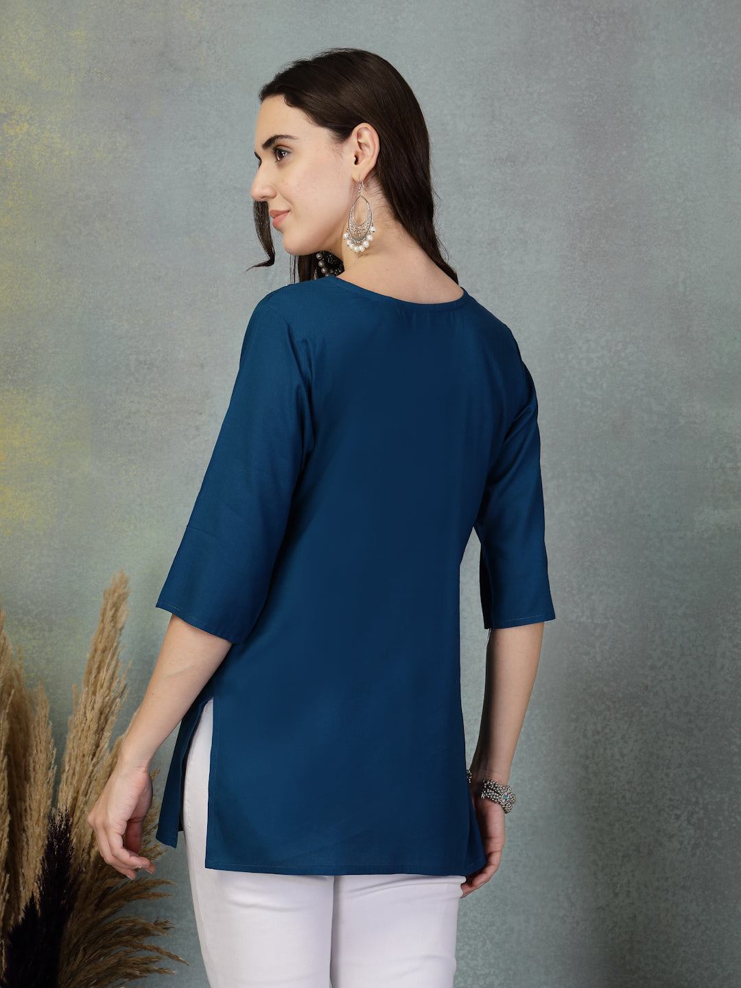 Peacock blue embroidered rayon kurti with three-quarter sleeves on model facing backward