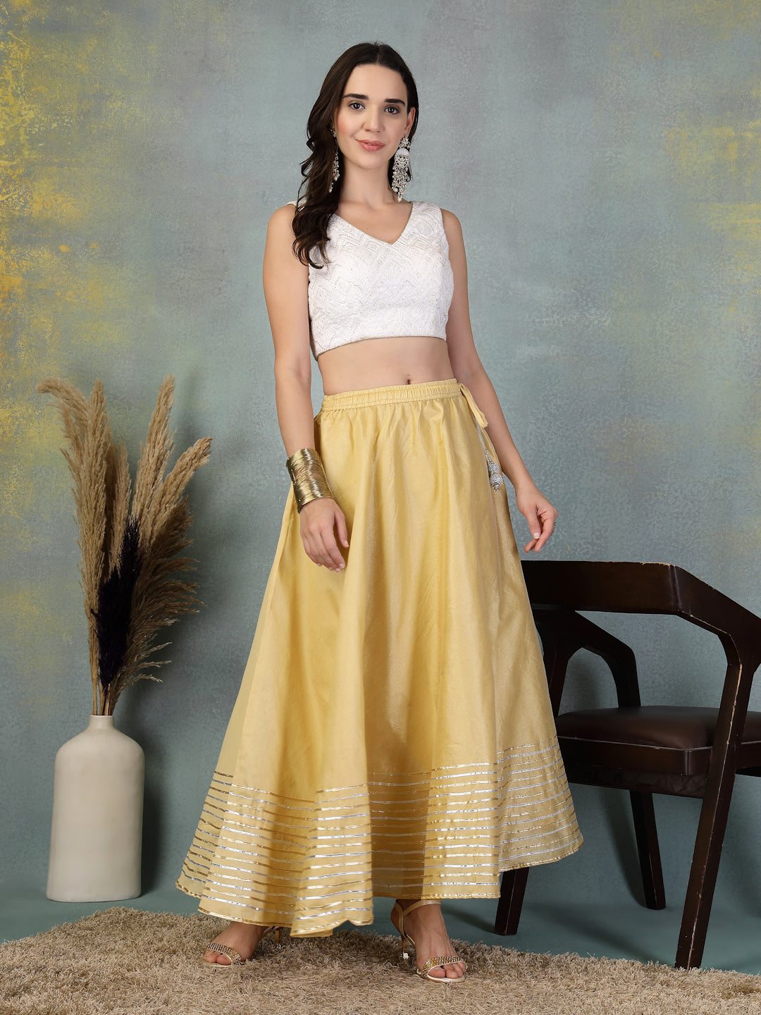 Woman wearing fawn gotta patti Chanderi silk flared skirt with white sleeveless crop top
