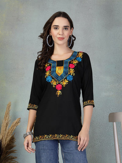 Black embroidered rayon kurti with colorful floral and geometric neckline design, three-quarter sleeves, and gold embroidery on cuffs and hem.