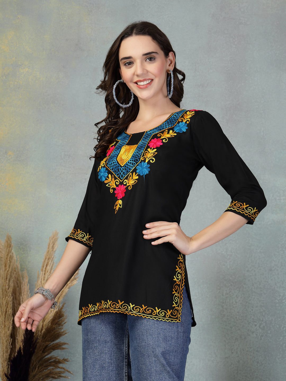Black embroidered rayon kurti with colorful floral design on neckline and sleeves, worn with jeans for casual chic look