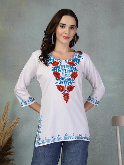 White embroidered rayon kurti with red and blue floral design, paired with jeans, worn by a woman