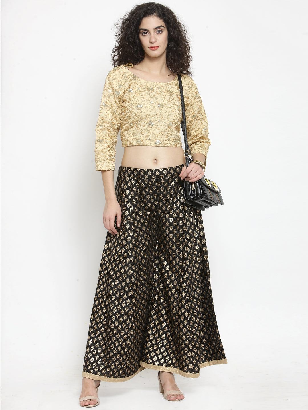Black printed rayon sharara with ethnic design, styled with a golden top.