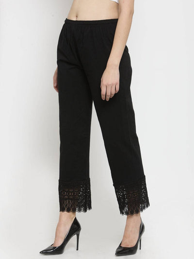 Black viscose lace palazzo with elegant lace detailing at the hem, styled with heels.