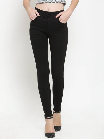 Black solid jeggings in regular fit, paired with high heels.