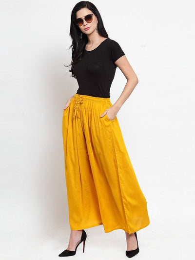Mustard solid rayon sharara worn by a woman with a black top and sunglasses.
