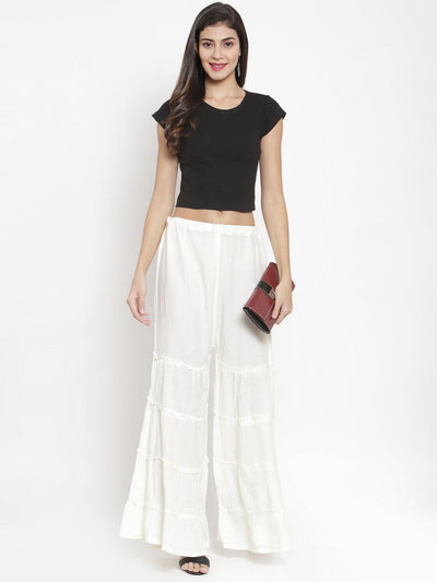 Cream flared solid Gharara styled with black top and clutch for a casual classy look.