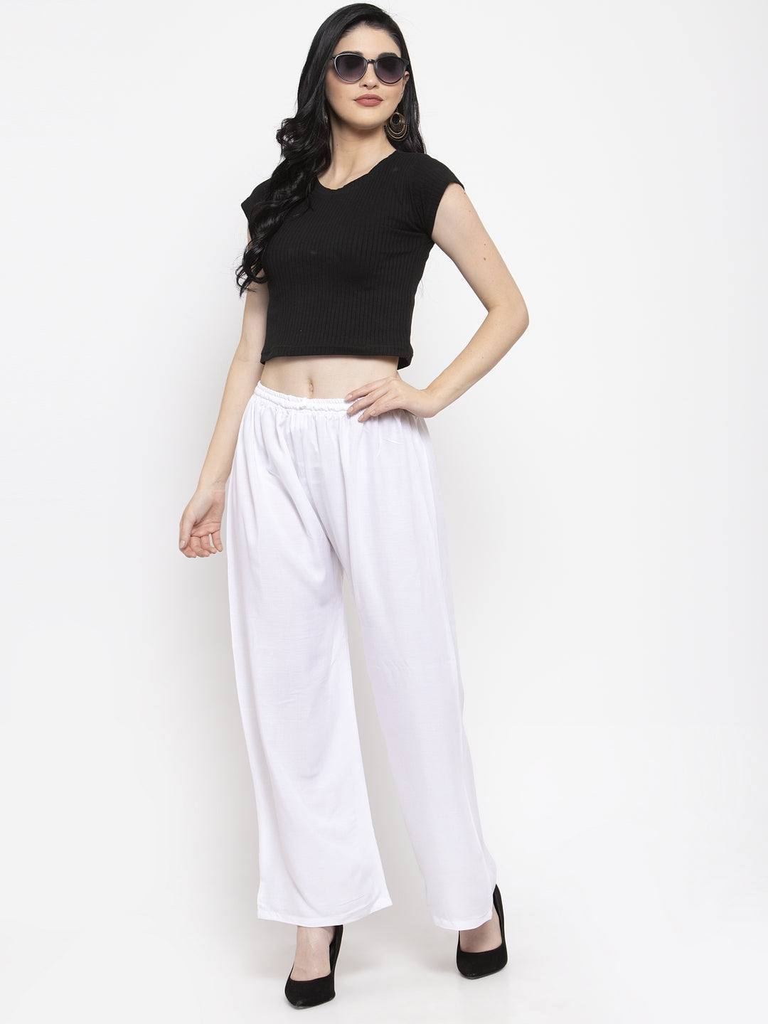 White solid rayon palazzo with elasticated waistband, paired with a black top and heels.