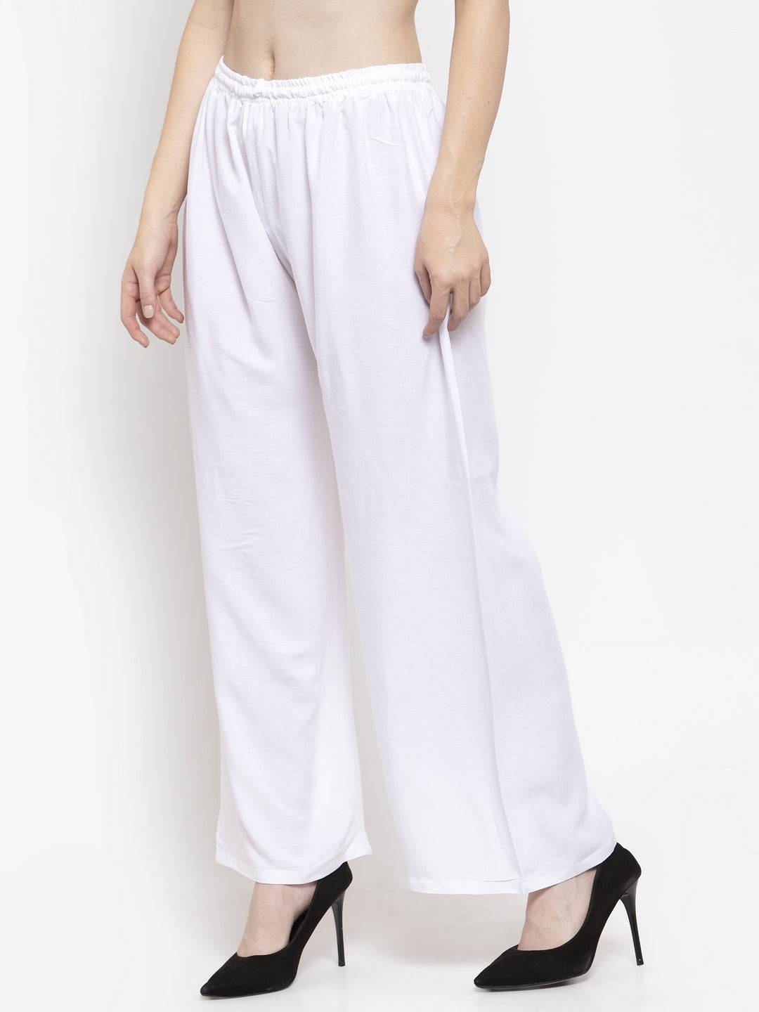 White solid rayon palazzo with elasticated waistband, styled with high heels.