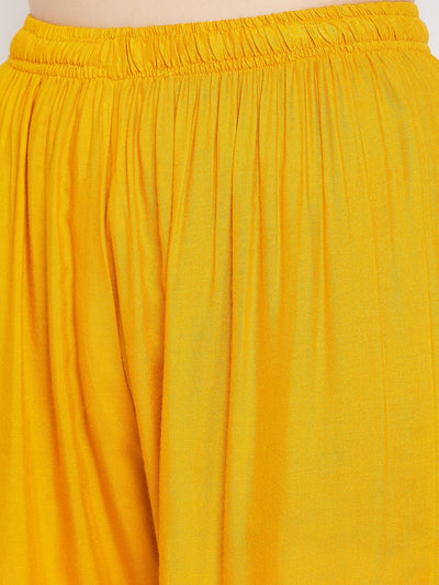 Mustard embellished rayon palazzo with elastic waistband and mirror work hem.
