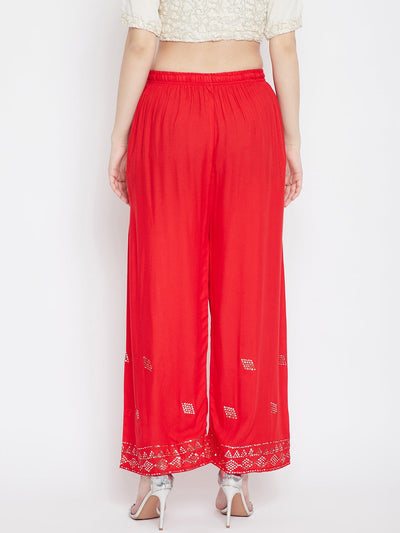 Red embellished rayon palazzo with elastic waistband and mirror work hem.