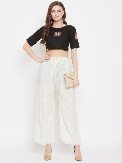 Cream straight printed palazzo with black crop top and heels.