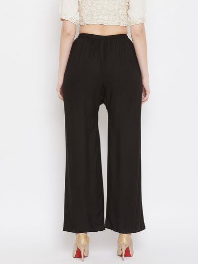 Black straight embellished palazzo with elastic waistband and stone work hem, made from rayon.