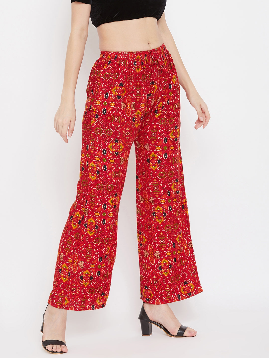 Red printed rayon palazzo with colorful pattern, paired with black heels.