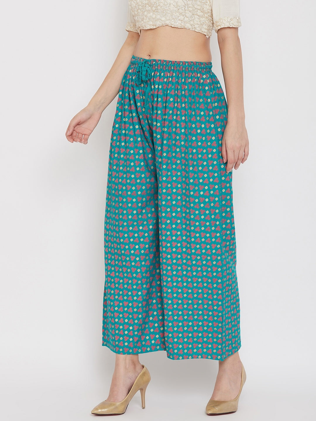 Turquoise straight printed palazzo pants made from lightweight rayon, worn by a woman.