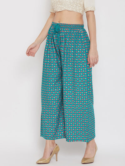 Turquoise straight printed palazzo pants made from lightweight rayon, worn by a woman.
