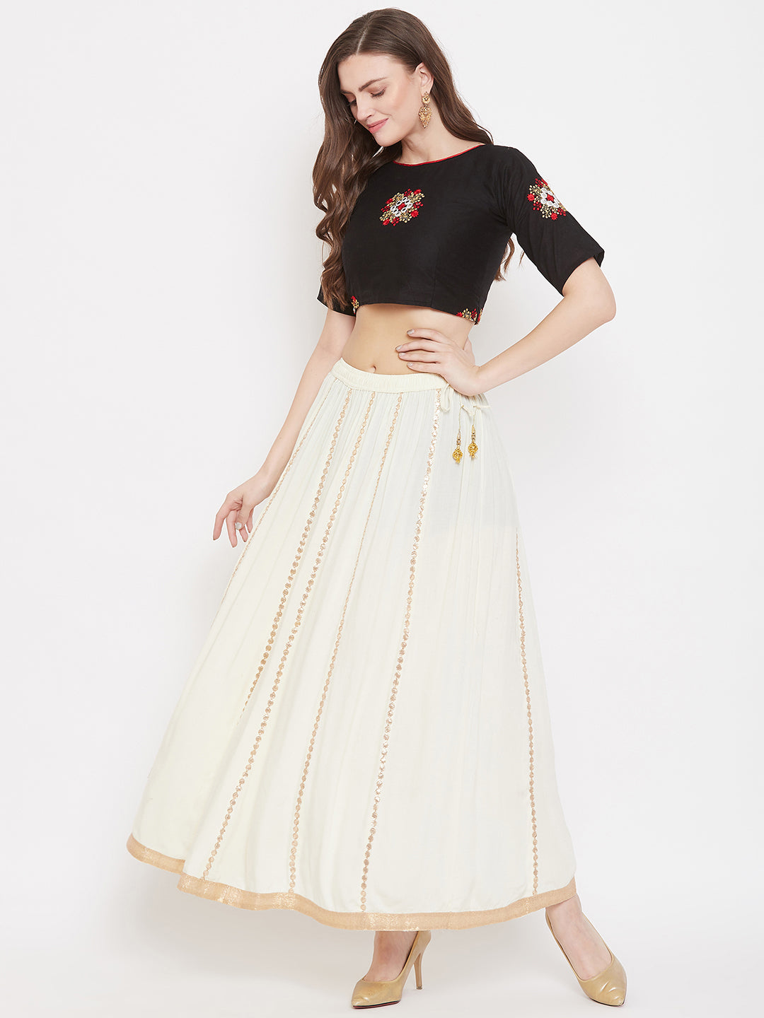 Cream Gotta Patti flared skirt in Rayon, styled with a blouse and high heels.