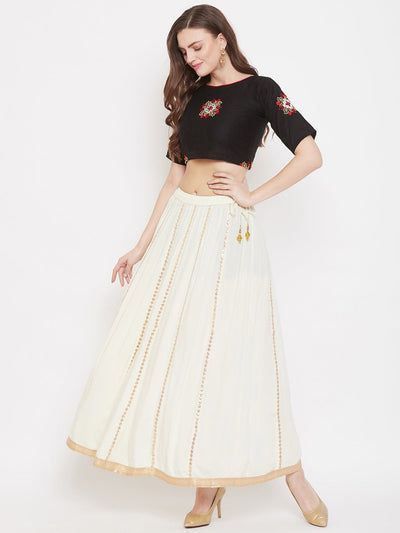 Cream Gotta Patti flared skirt in Rayon, styled with a blouse and high heels.