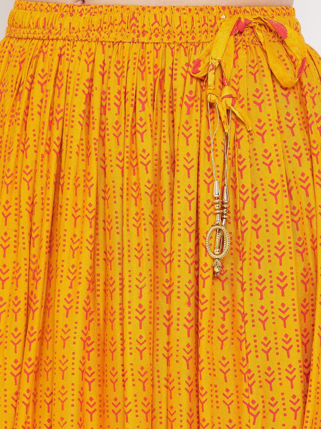 Mustard printed rayon flared skirt with decorative tassels.