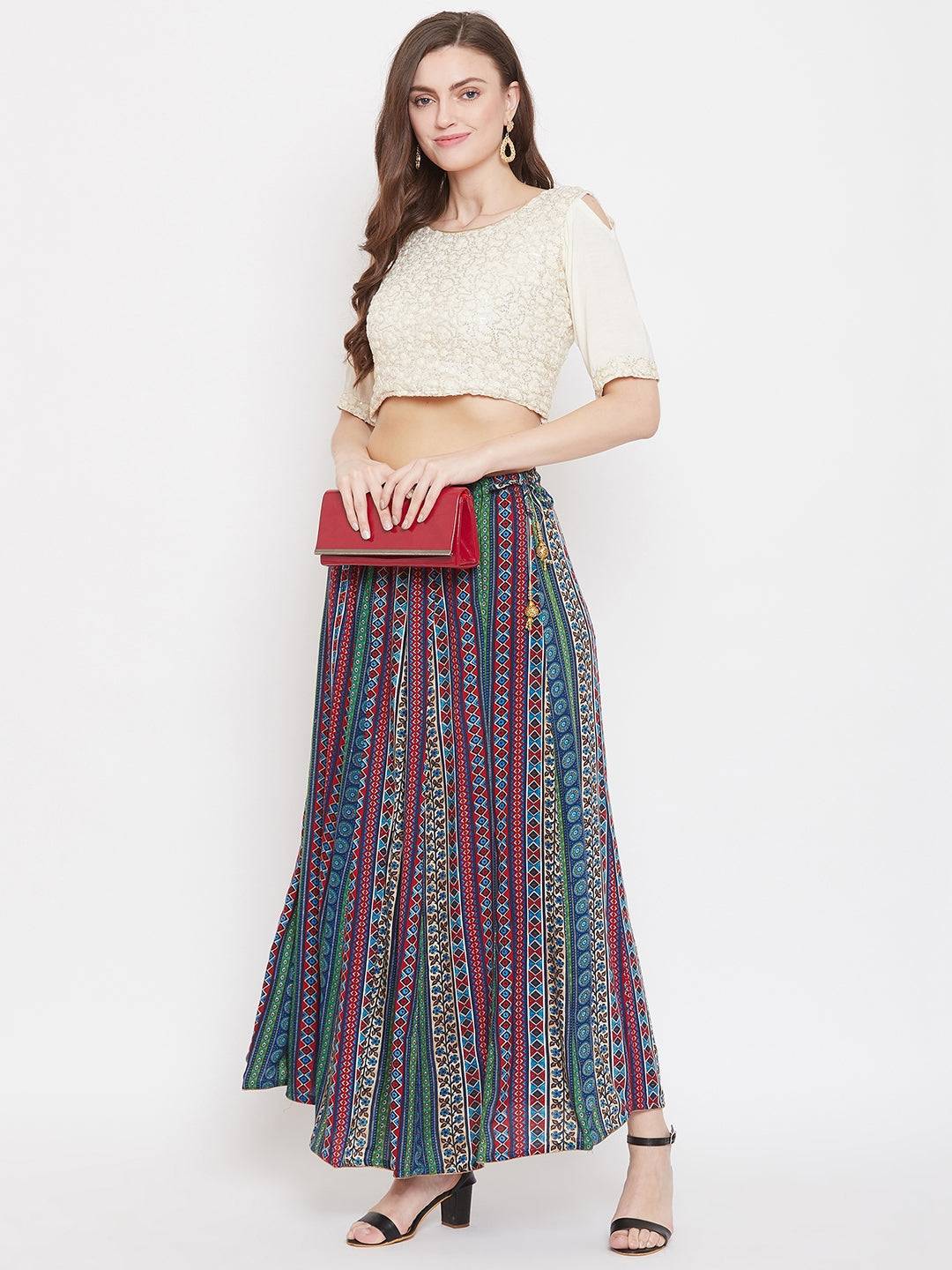 Multi flared printed maxi skirt in vibrant colors on woman with blouse and heels.
