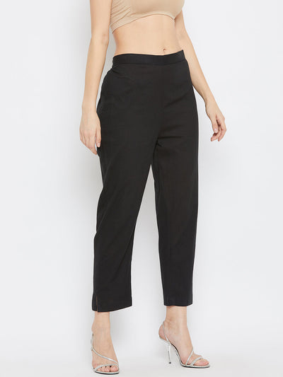 Black regular fit solid pants for women made from lightweight cotton fabric.