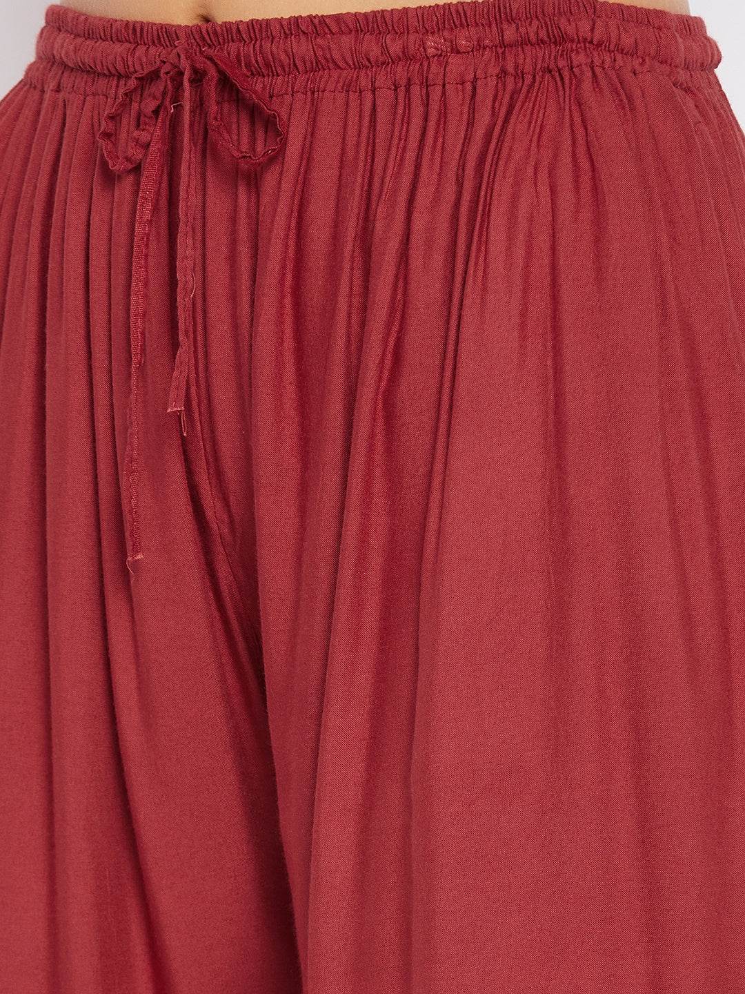 Rust solid rayon sharara with elastic waist and tie detail.