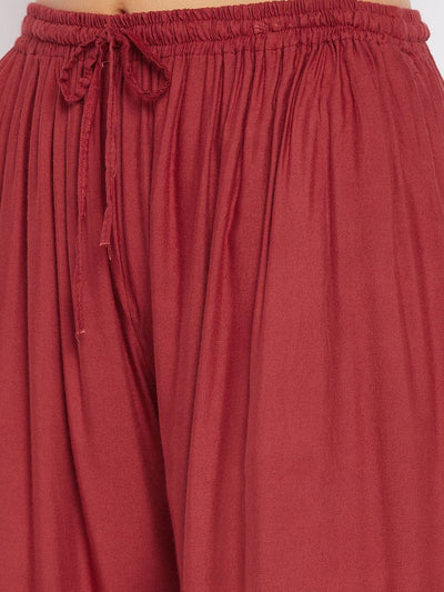 Rust solid rayon sharara with elastic waist and tie detail.