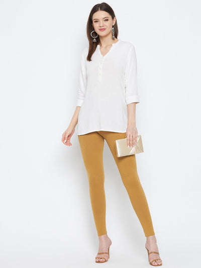 Fawn solid ankle length leggings made from cotton lycra fabric for comfort, styled with a white kurta and heels.