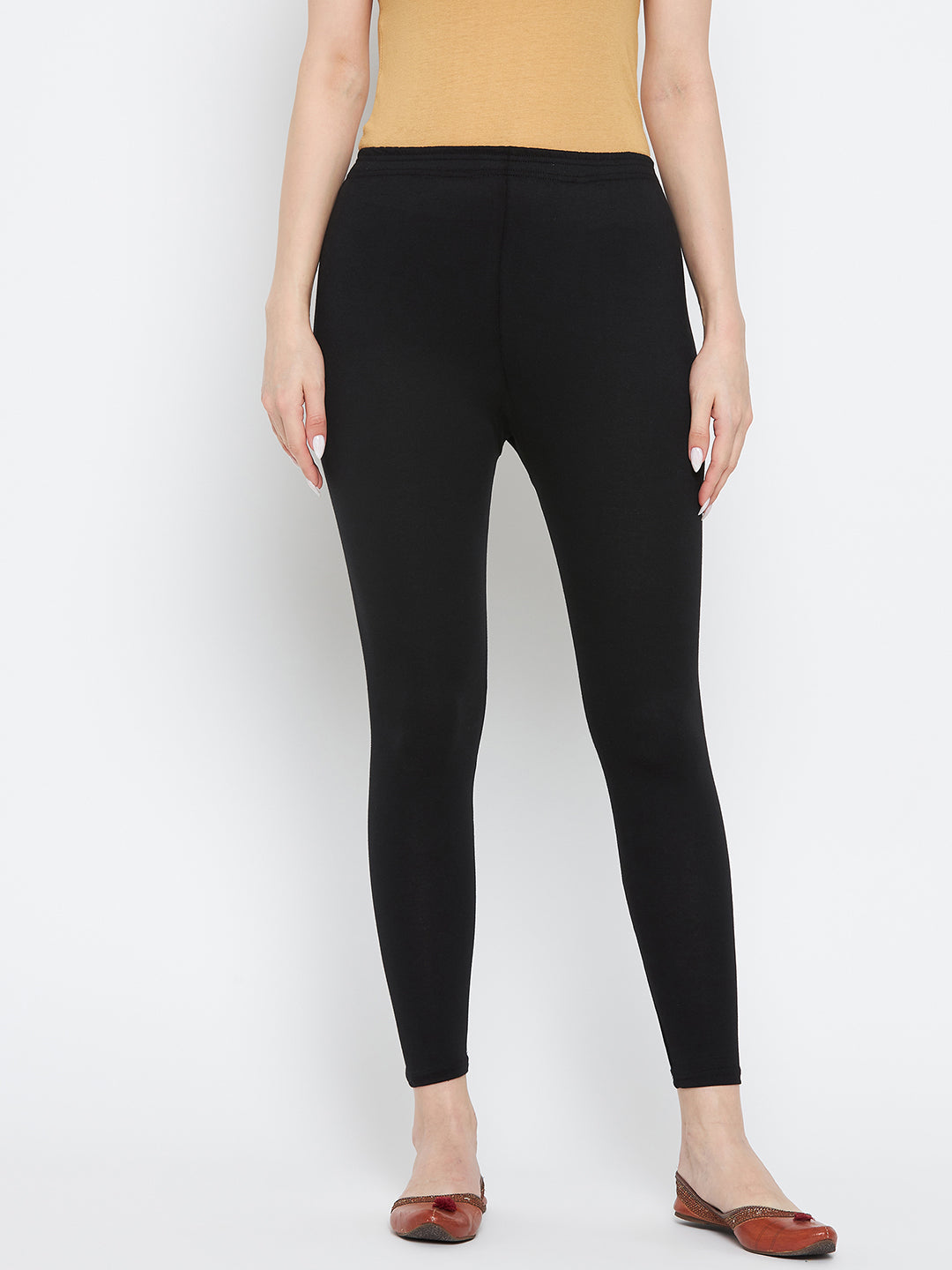 Black solid ankle length leggings made from premium cotton lycra fabric, ideal for pairing with a Kurta and high heels.