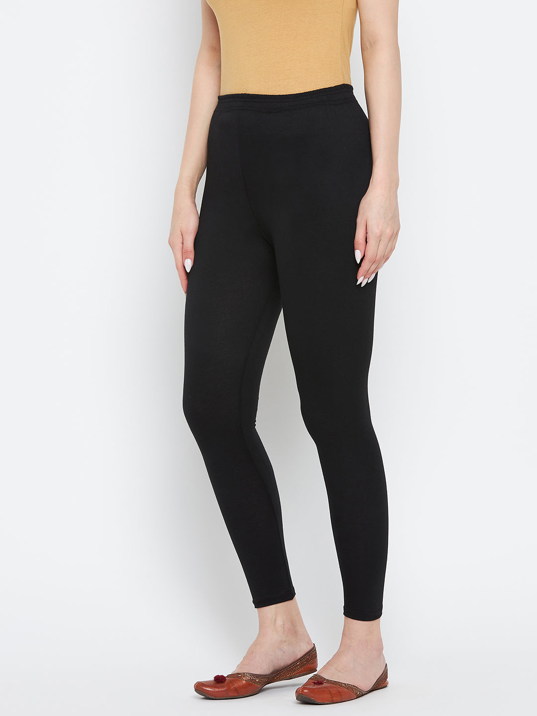 Black solid ankle length leggings made from cotton lycra fabric.