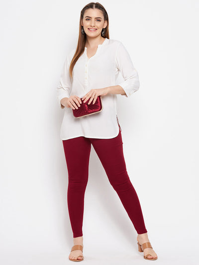 Maroon solid woolen leggings paired with white kurta and heels.