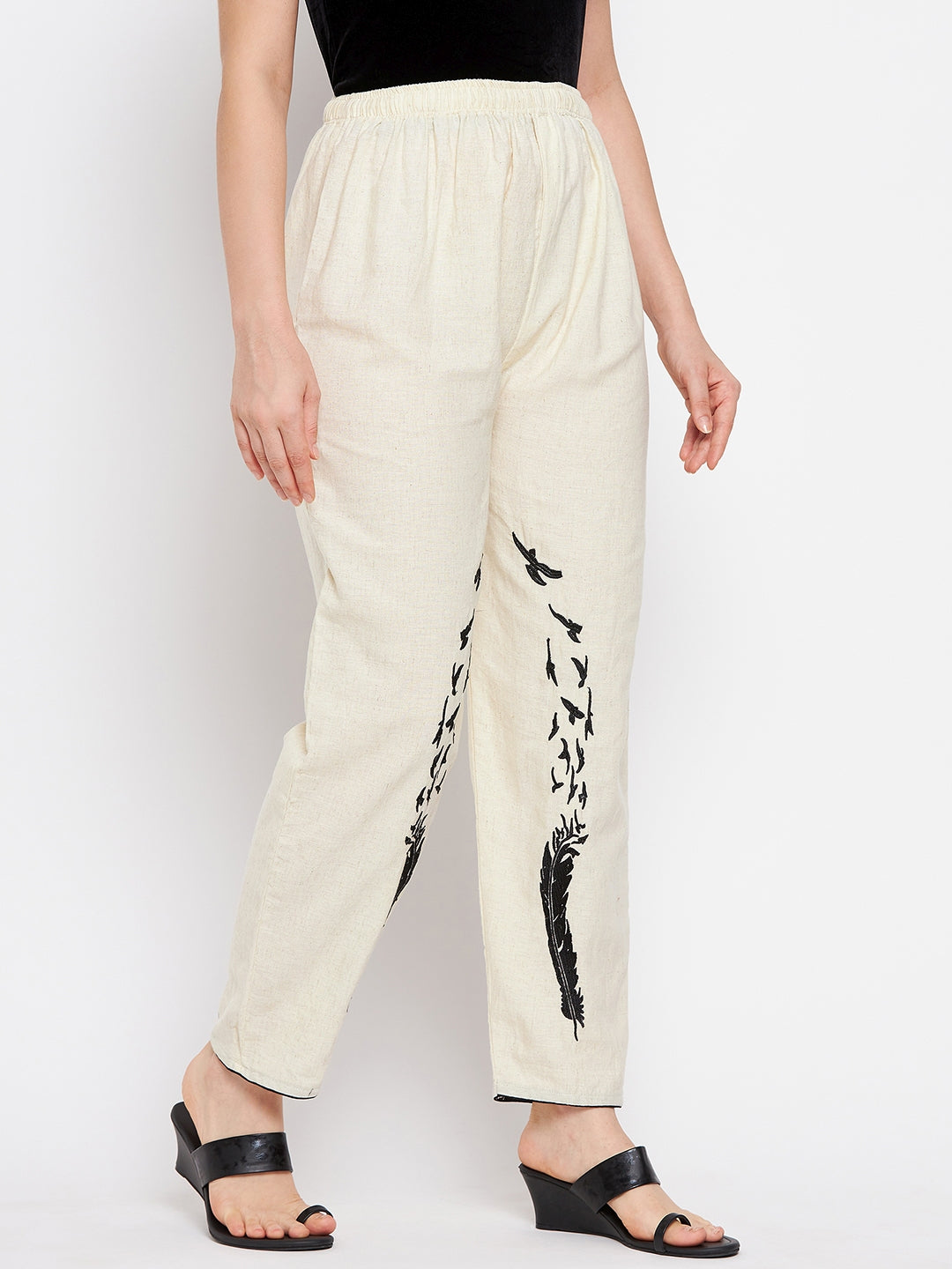 Beige embroidered trouser with black design on leg, elasticated waistband, made from fine cotton fabric.