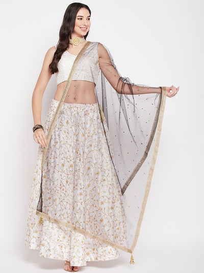 Black sequinned net dupatta with tasselled border draped over woman in traditional attire.