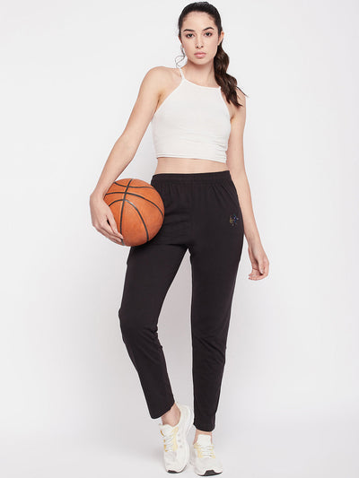 Black solid mid rise cotton track pants with elastic waistband and zip pocket.