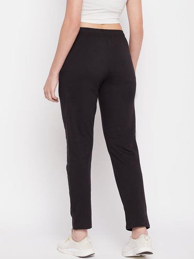 Black solid mid rise cotton track pants with elasticated waistband and drawstring.