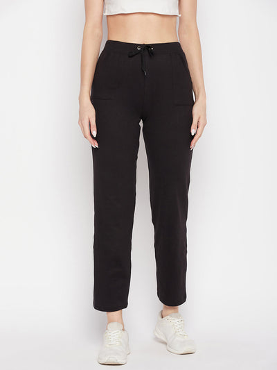 Black solid mid rise cotton trackpants with elasticated waistband and drawstring closure.