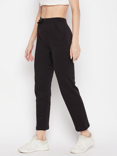 Black solid mid rise cotton trackpants with elasticated waistband and drawstring closure.