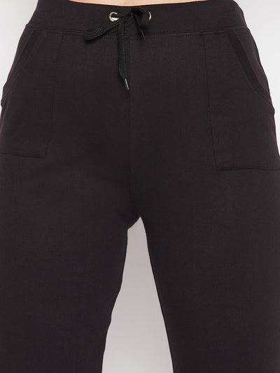 Black solid mid-rise cotton trackpants with elastic waistband and drawstring.