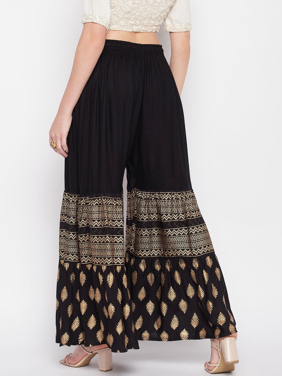 Black printed rayon flared gharara with elasticated waistband and drawstring.